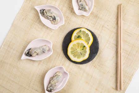 oyster dish with lemon slice on burlap background.の写真素材