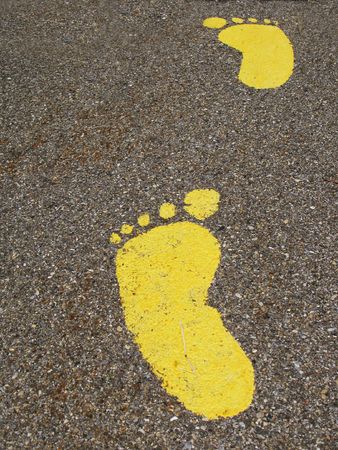 Yellow footmarks on asphaltの写真素材