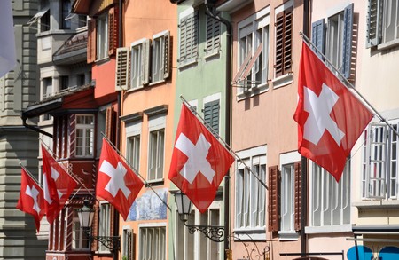 Old street in Zurich decorated with flags for the Swiss National Day, 1st of August の写真素材