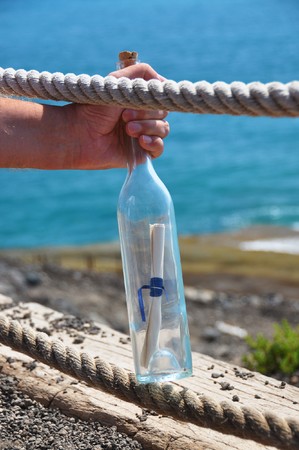 Bottle with a message in the handの写真素材