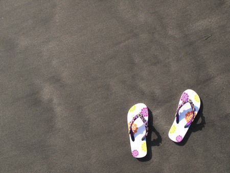  Flip-flops and hat on the black sand of Tenerife island, Canariesの写真素材