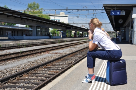 Girl with a suitcase at the train station のeditorial素材