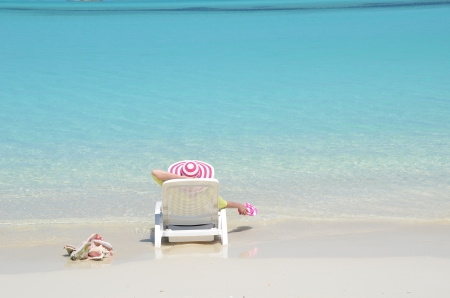 Girl in a striped hat on the beach of Exuma, Bahamasの写真素材