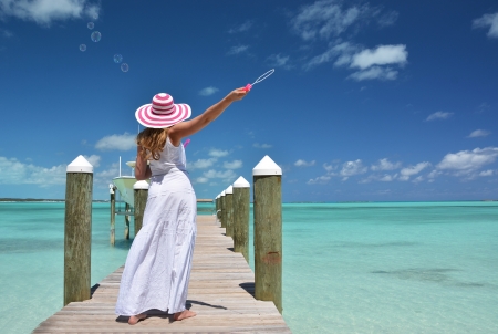 Girl on the wooden jetty making soap bubbles. Exuma, Bahamas の写真素材