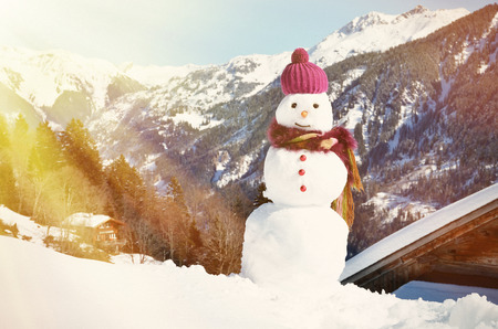 Snowman against Alpine panoramaの写真素材