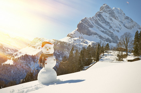 Snowman against Alpine panoramaの写真素材
