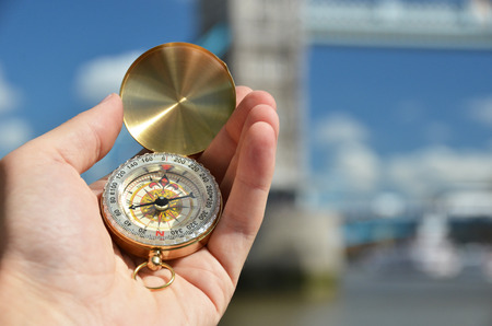 Compass in the hand against Tower bridge in Londonの写真素材