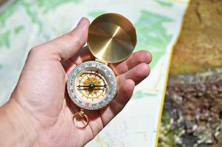 Vintage compass in the hand against a mapの写真素材