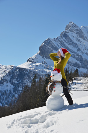 Girl decorating a snowmanの写真素材