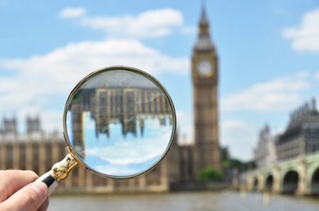 Magnifying glass in the hand against Big Ben in Londonの写真素材