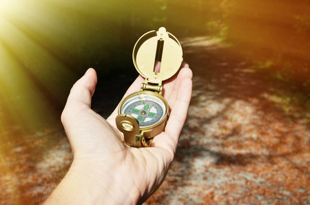 Compass in the hand against against wood