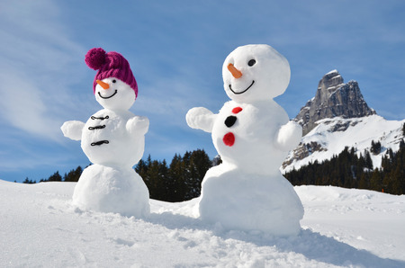 Funny snowmen against Swiss Alpsの写真素材