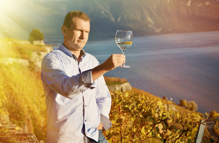 Man holding a glass of wine. Lavaux, Switzerlandの写真素材