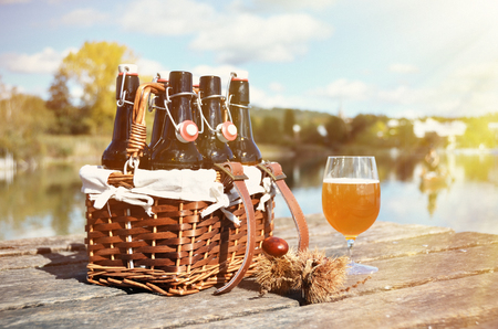 Beer bottles in the vintage basket on a wooden pierの写真素材
