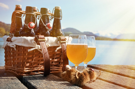 Beer bottles in the vintage basket on a wooden pierの写真素材