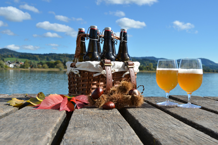 Beer bottles in the vintage basket on a wooden pierの写真素材