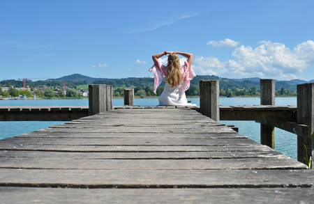 Girl on the wooden jetty at the lake. Switzerlandの写真素材