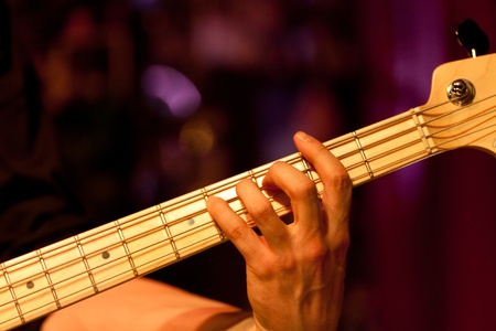 hand of a bass player while playing the bass, colorful backgroundの写真素材