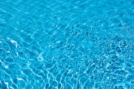 Abstract background of cool inviting sparkling blue water shimmering with reflections from the summer sunの写真素材