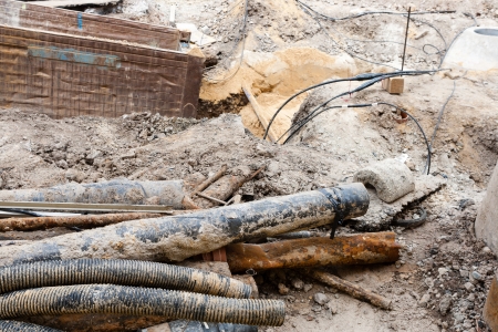 Image of some old and rusty pipes being taken out of the surface の写真素材