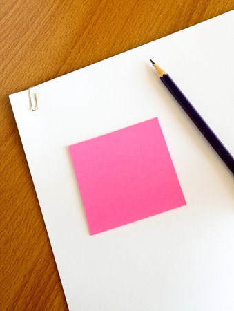 white paper with pencil and pink memo on wood tableの写真素材