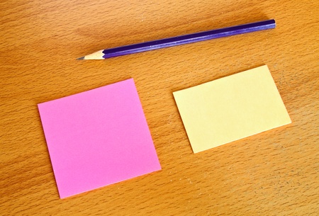 Yellow and pink memo with pencil on wood tableの写真素材
