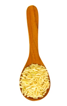 brown rice over the wooden spoon isolatedの写真素材