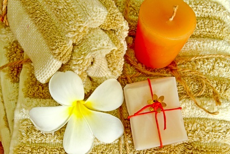 Spa products with flower and candle on towelの写真素材