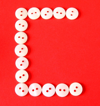 Letter "C" from buttons on a red backgroundの写真素材