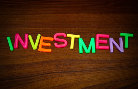 Investment in colorful toy letters on wood backgroundの写真素材