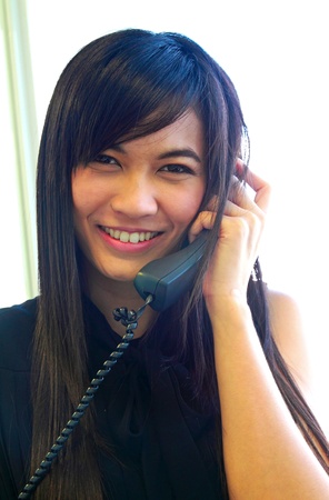 Young asian businesswoman using telephoneの写真素材