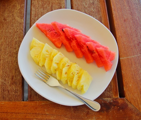 Watermelon and pineapple on dish with forkの写真素材