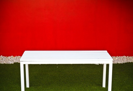 white bench with red wallの写真素材