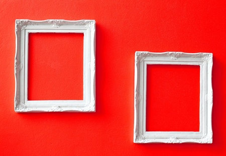 Two white vintage frames on red wall の写真素材