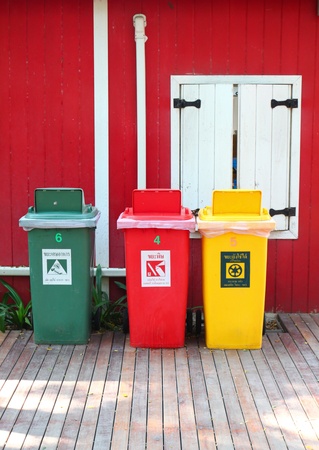 Colorful recycle bins in front of the houseの写真素材