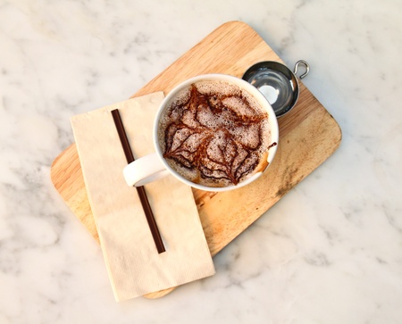 Hot chocolate with syrup on chopping boardの写真素材