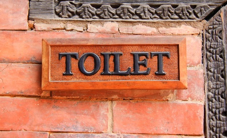 Ancient toilet sign on brick wallの写真素材