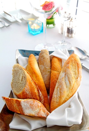 Sliced baguette with kitchenware on tableの写真素材