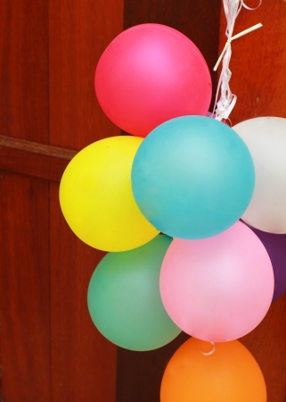 Multicolored balloons hanging on wooden doorの写真素材