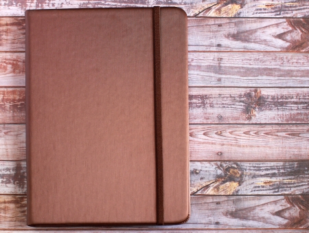 silk brown cover note book on wooden background の写真素材