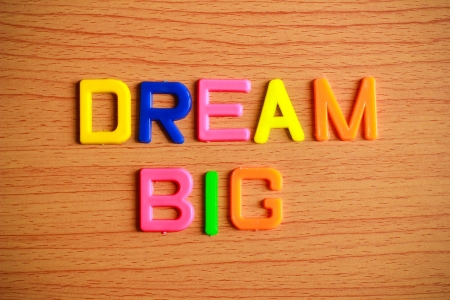 Dream big in colorful plastic letterpress on wood backgroundの写真素材