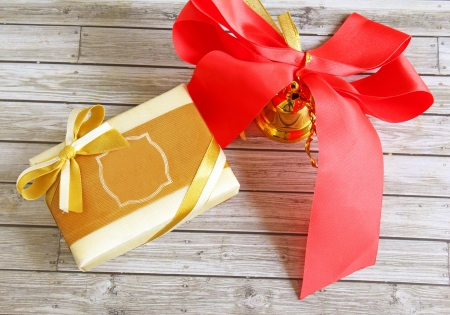 Gift box and red ribbon over wooden background の写真素材