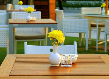 Table and chair setting with flower in outdoor restaurantの写真素材