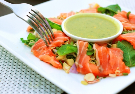 Spicy salmon salad and wasabi sauce with forkの写真素材