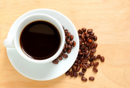 Coffee cup and beans on wooden tableの写真素材
