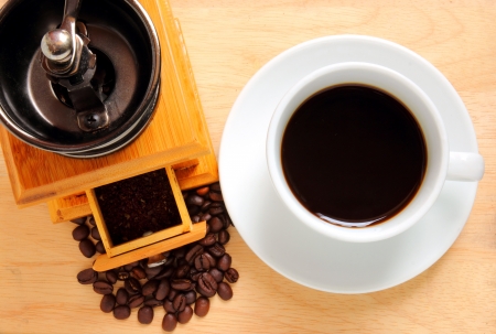 Cup of hot coffee with coffee grinder and beans の写真素材