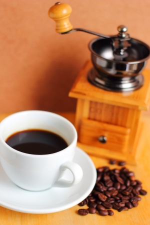 Cup of hot coffee with coffee grinder and beans の写真素材