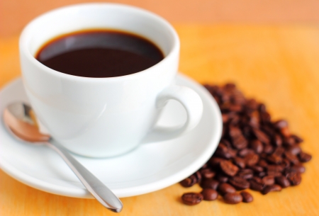 White cup of coffee with coffee beansの写真素材