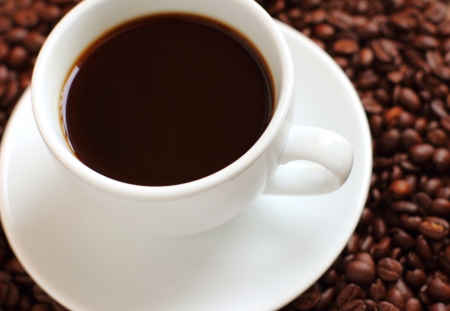 White cup of coffee on coffee beansの写真素材