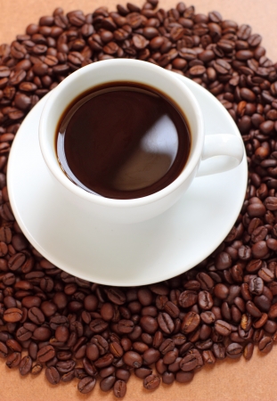 Cup of coffee on coffee beansの写真素材